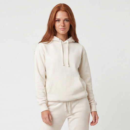 Woman wearing a cream-colored hoodie and pants on a light gray background