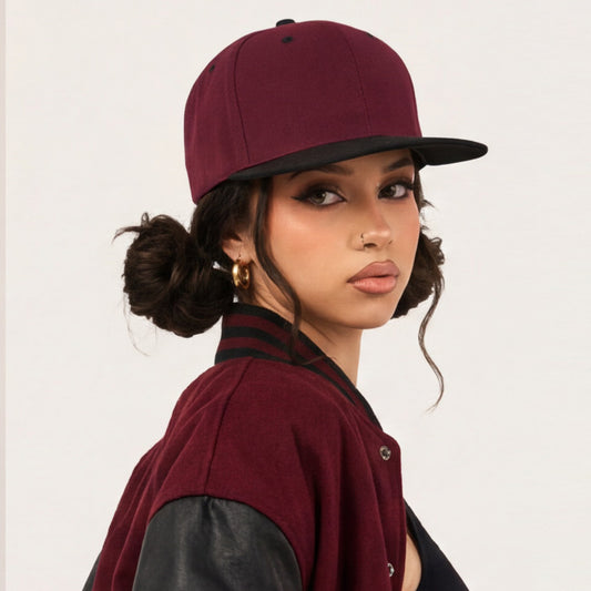 Woman wearing a maroon snapback cap flat visor bill and vest on a white background