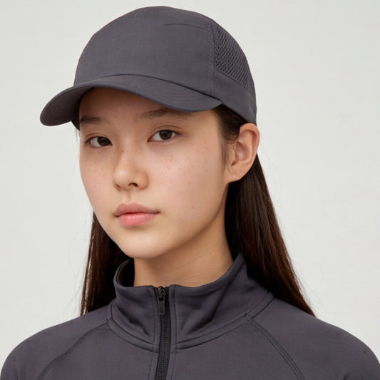 Person wearing a dark gray light weight running cap and matching jacket on a light gray background