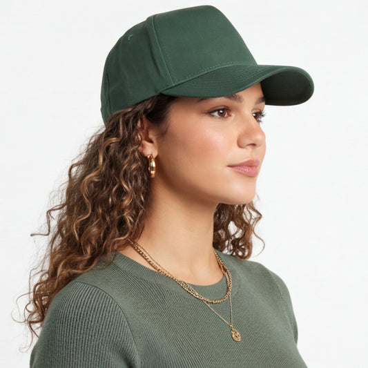 Woman wearing a green trucker cap and sweater on a white background