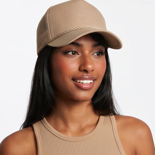 Woman wearing a beige trucker cord cap and tank top on a white background
