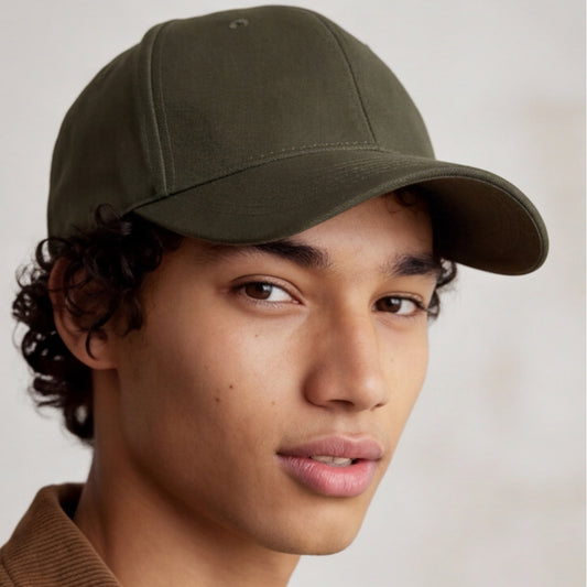Person wearing a green 6 panel structured baseball cap against a neutral background