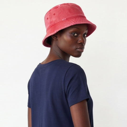 Person wearing a red bucket hat and navy shirt on a plain background