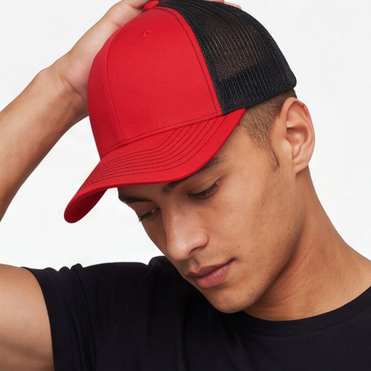Person wearing a red and black 6 panel trucker cap on a white background
