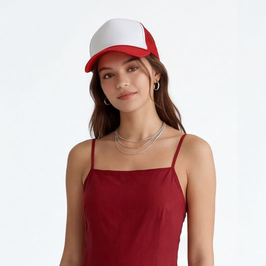 Woman wearing a red tank top and white and red trucker foam cap on a light gray background